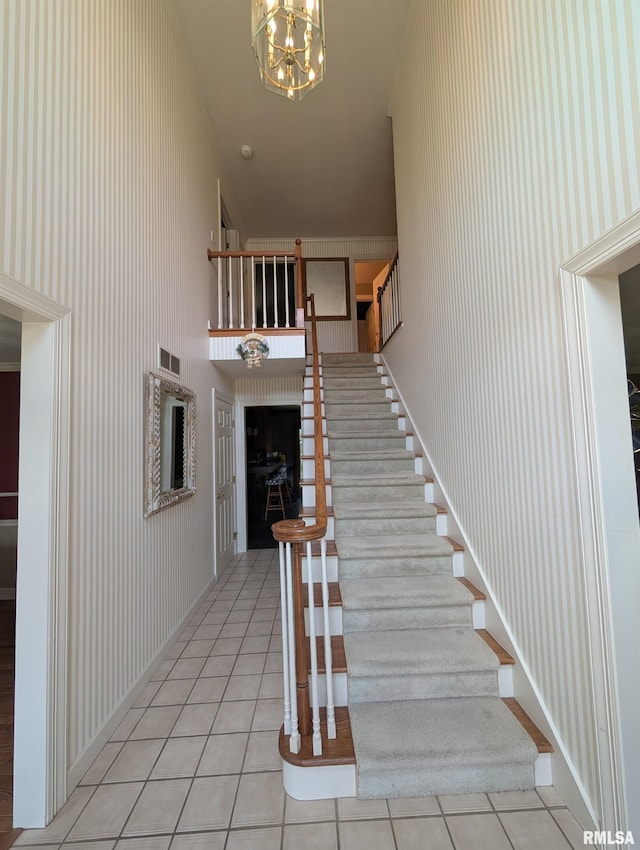 1315 W Wexford Pl, Peoria, IL 61615 - stairway featuring tile patterned flooring, a chandelier, and a fireplace