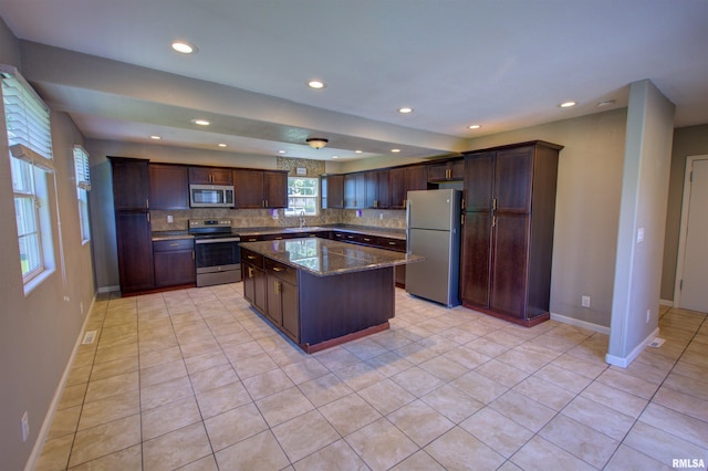 1008 5th Ave, Camanche, IA 52730 - kitchen with stainless steel appliances, recessed lighting, backsplash, a kitchen island, and dark brown cabinets