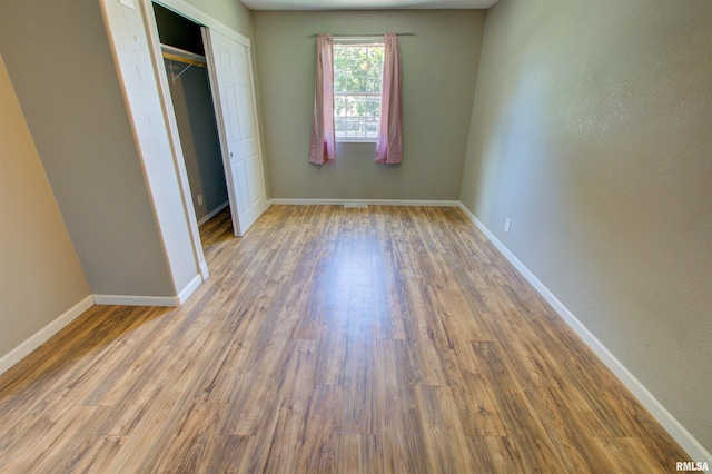 1008 5th Ave, Camanche, IA 52730 - unfurnished bedroom featuring wood finished floors and a closet