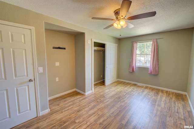 1008 5th Ave, Camanche, IA 52730 - unfurnished bedroom with wood finished floors, a closet, a textured ceiling, and ceiling fan