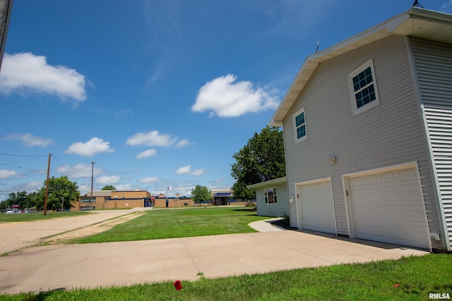 1008 5th Ave, Camanche, IA 52730 - view of home's exterior with an attached garage, concrete driveway, and a yard