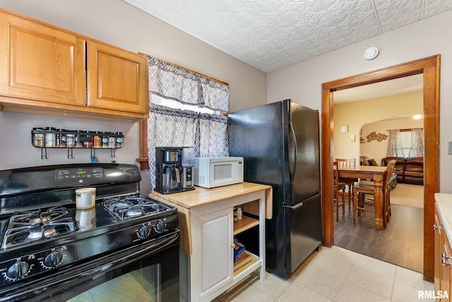 240 15th Ave, East Moline, IL 61244 - kitchen with black appliances, light countertops, arched walkways, an ornate ceiling, and plenty of natural light