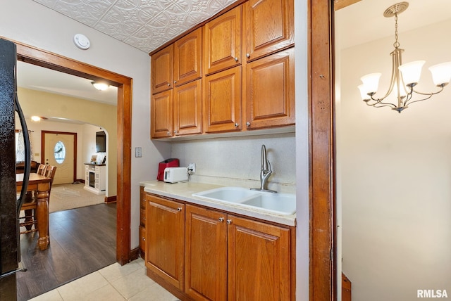 240 15th Ave, East Moline, IL 61244 - kitchen featuring arched walkways, brown cabinets, light countertops, a chandelier, and an ornate ceiling