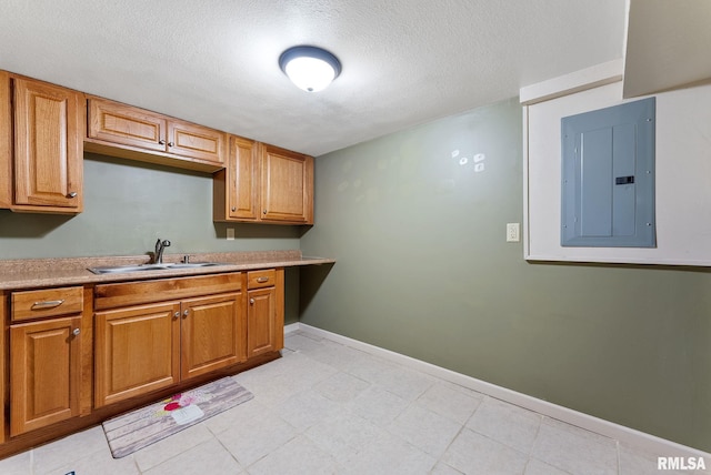 240 15th Ave, East Moline, IL 61244 - kitchen with electric panel, a textured ceiling, light countertops, brown cabinets, and light tile patterned floors