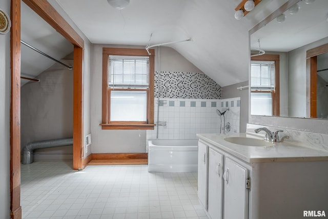 1035 W Locust St, Davenport, IA 52804 - bathroom featuring vanity, healthy amount of natural light, vaulted ceiling, washtub / shower combination, and tile patterned floors