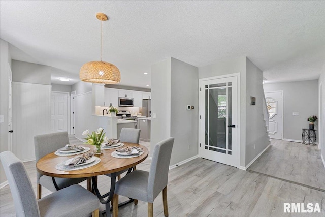 4050 4th St Unit B, East Moline, IL 61244 - dining space with light wood finished floors and a textured ceiling