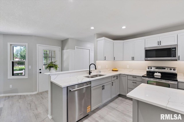4050 4th St Unit B, East Moline, IL 61244 - kitchen with appliances with stainless steel finishes, light wood-style flooring, gray cabinets, light stone countertops, and recessed lighting