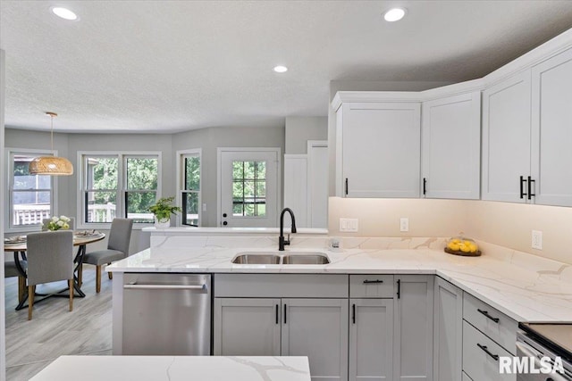 4050 4th St Unit B, East Moline, IL 61244 - kitchen featuring stainless steel dishwasher, a peninsula, decorative light fixtures, light stone countertops, and recessed lighting