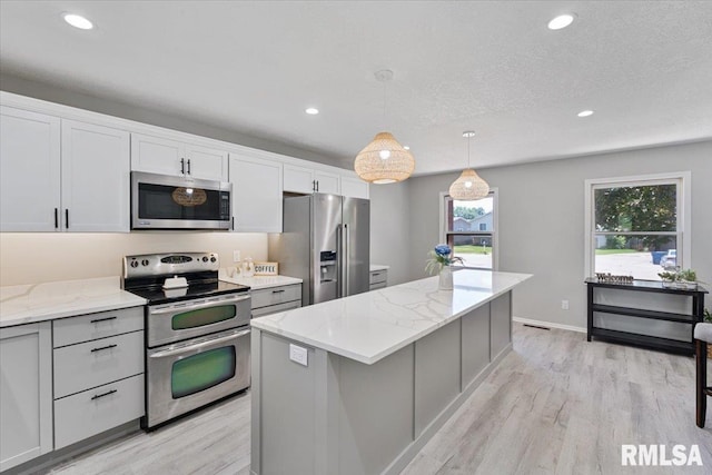 4050 4th St Unit B, East Moline, IL 61244 - kitchen with appliances with stainless steel finishes, a center island, light wood-style floors, plenty of natural light, and recessed lighting