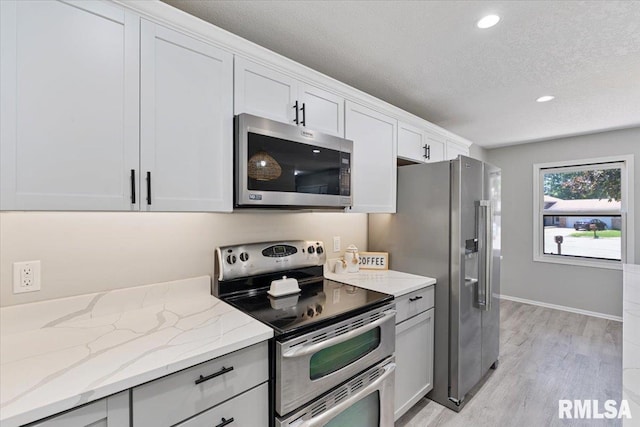 4050 4th St Unit B, East Moline, IL 61244 - kitchen with stainless steel appliances, a textured ceiling, light wood-type flooring, light stone counters, and recessed lighting