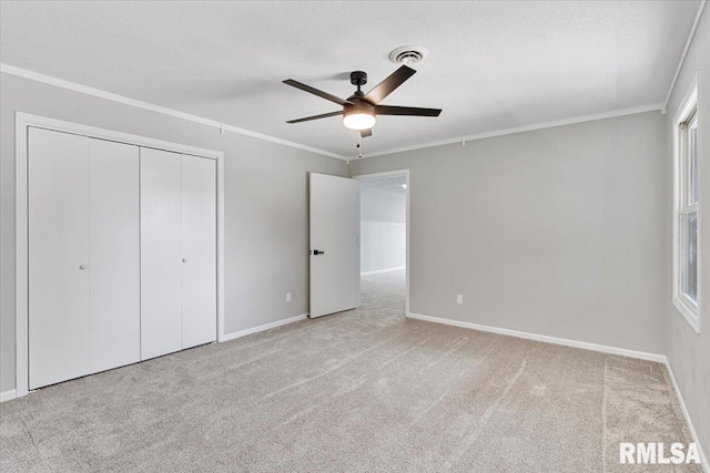 4050 4th St Unit B, East Moline, IL 61244 - unfurnished bedroom featuring carpet flooring, a closet, crown molding, a ceiling fan, and a textured ceiling