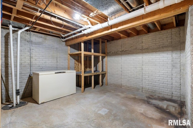 4050 4th St Unit B, East Moline, IL 61244 - unfinished below grade area featuring white refrigerator and brick wall