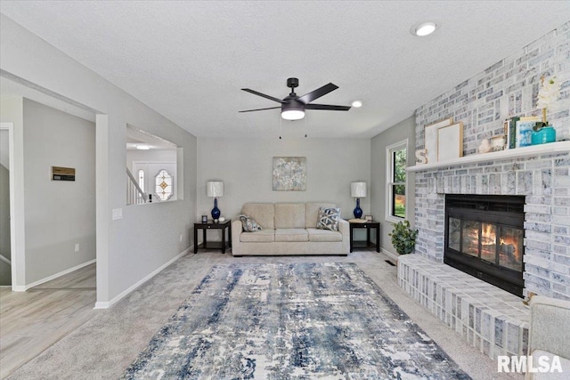 4050 4th St Unit B, East Moline, IL 61244 - living area featuring ceiling fan, a fireplace, a textured ceiling, carpet, and stairs