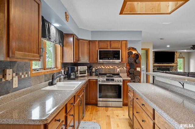 910 Fyre Lake Dr, Sherrard, IL 61281 - kitchen featuring appliances with stainless steel finishes, plenty of natural light, light wood-type flooring, brown cabinets, and recessed lighting