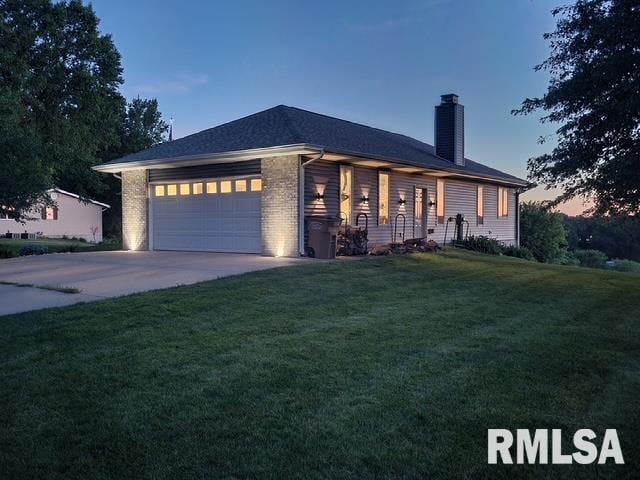 910 Fyre Lake Dr, Sherrard, IL 61281 - view of front of home featuring a chimney, a yard, a garage, concrete driveway, and brick siding