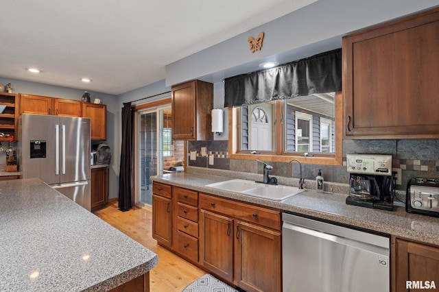 910 Fyre Lake Dr, Sherrard, IL 61281 - kitchen featuring appliances with stainless steel finishes, light wood-style flooring, decorative backsplash, brown cabinets, and recessed lighting