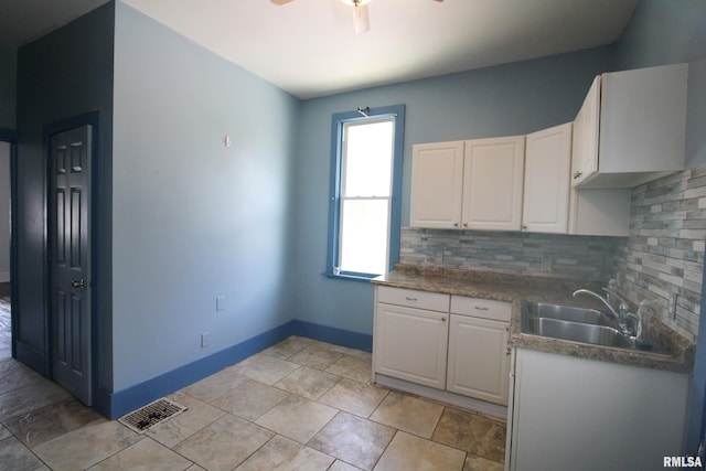 1416 Payson Ave, Quincy, IL 62301 - kitchen with ceiling fan, backsplash, and white cabinetry