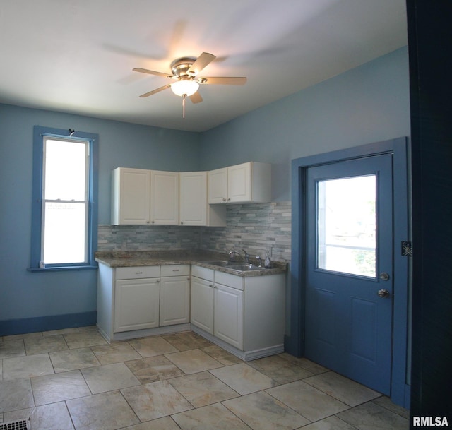 1416 Payson Ave, Quincy, IL 62301 - kitchen featuring a ceiling fan, white cabinets, and tasteful backsplash
