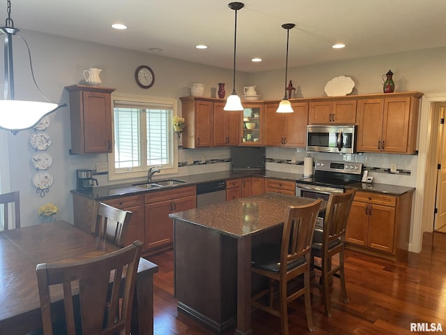 1175 Rustic View Ct, Eldridge, IA 52748 - kitchen with stainless steel appliances, brown cabinetry, dark wood finished floors, tasteful backsplash, and recessed lighting