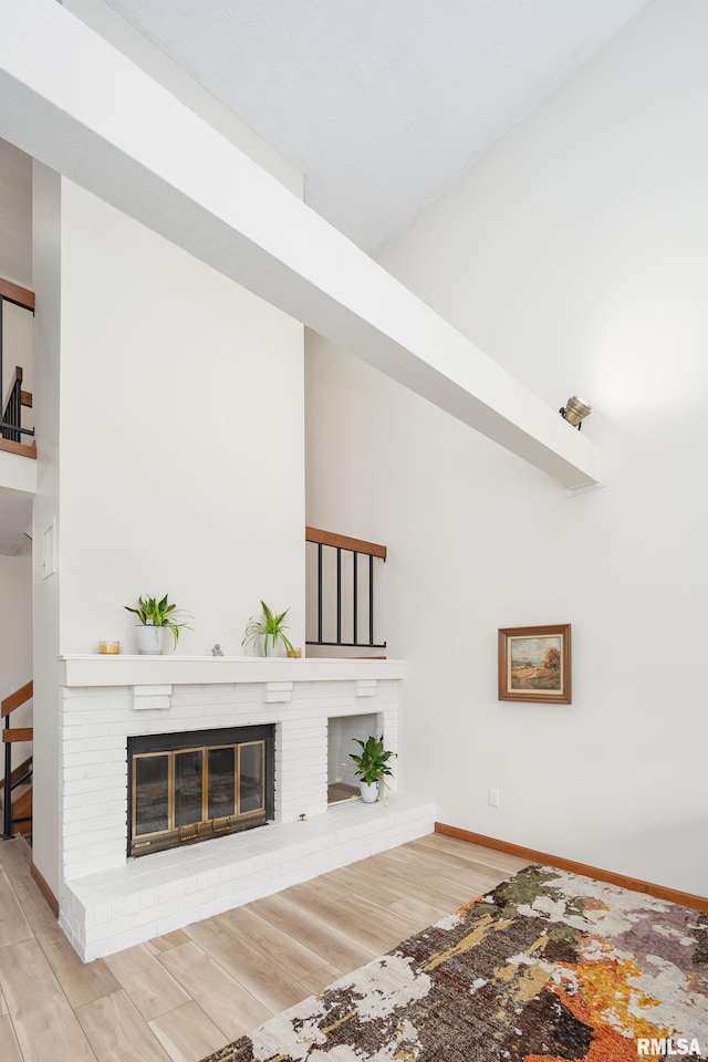 4554 Bunker Hill Dr, Bettendorf, IA 52722 - unfurnished living room featuring a fireplace, wood finished floors, and a high ceiling