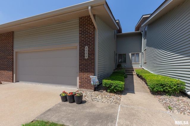 4554 Bunker Hill Dr, Bettendorf, IA 52722 - view of side of home with brick siding, driveway, and a garage