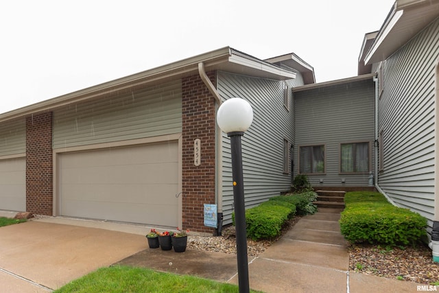 4554 Bunker Hill Dr, Bettendorf, IA 52722 - view of front of home featuring brick siding, an attached garage, and concrete driveway