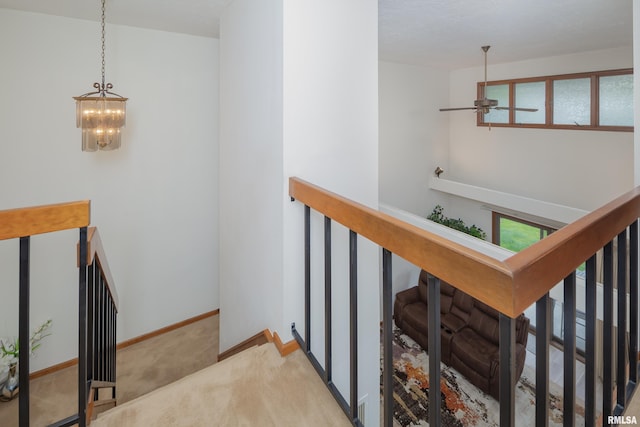 4554 Bunker Hill Dr, Bettendorf, IA 52722 - stairway with carpet, a chandelier, and a ceiling fan