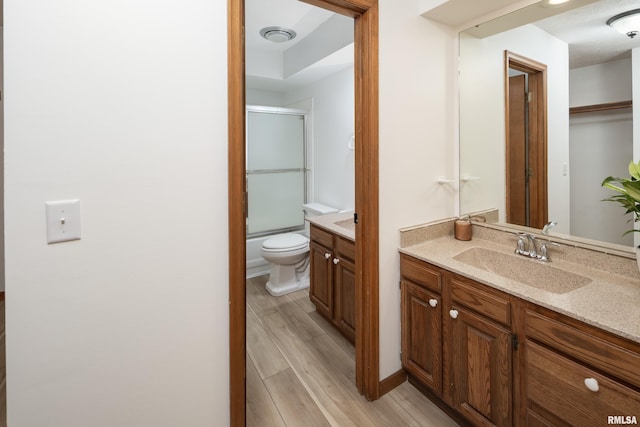 4554 Bunker Hill Dr, Bettendorf, IA 52722 - full bath with vanity, wood finished floors, and shower / bath combination with glass door