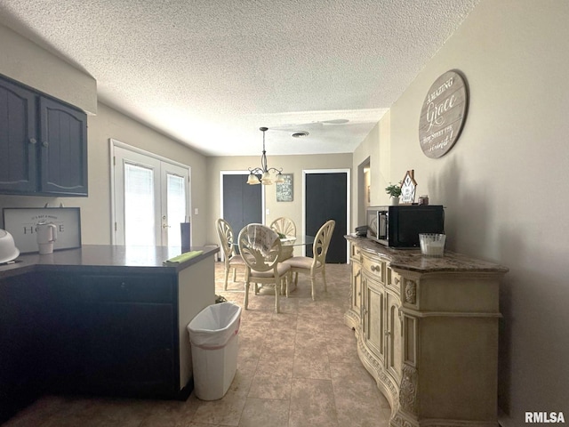 502 S Day St, West Frankfort, IL 62896 - kitchen with a chandelier, a textured ceiling, dark countertops, french doors, and pendant lighting