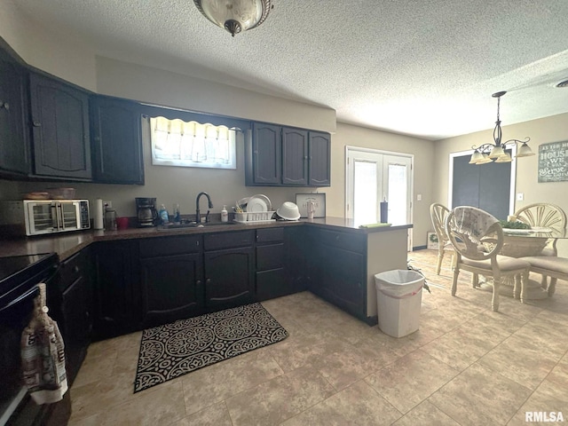 502 S Day St, West Frankfort, IL 62896 - kitchen featuring a peninsula, a chandelier, black range with electric cooktop, dark countertops, and a textured ceiling