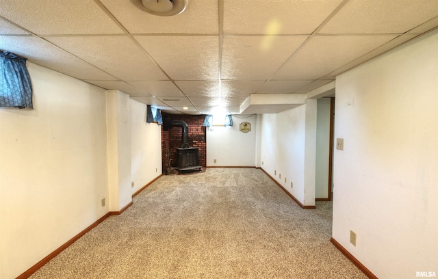 1221 4th St, Camanche, IA 52730 - finished below grade area with a wood stove, a drop ceiling, and carpet flooring
