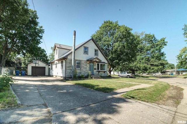 1221 4th St, Camanche, IA 52730 - view of front of property with an outbuilding, a garage, driveway, stone siding, and a front yard
