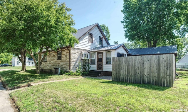 1221 4th St, Camanche, IA 52730 - view of side of home featuring stone siding, entry steps, and a metal roof
