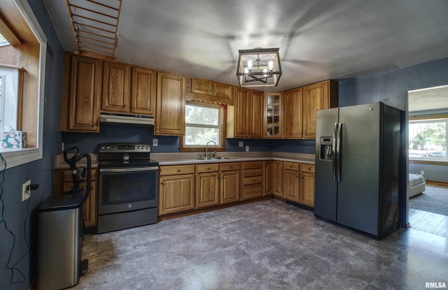 1221 4th St, Camanche, IA 52730 - kitchen with appliances with stainless steel finishes, under cabinet range hood, glass insert cabinets, brown cabinetry, and light countertops
