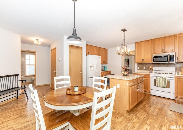 624 Mineral Creek Dr, Colona, IL 61241 - kitchen featuring white appliances, light countertops, light wood-type flooring, and backsplash