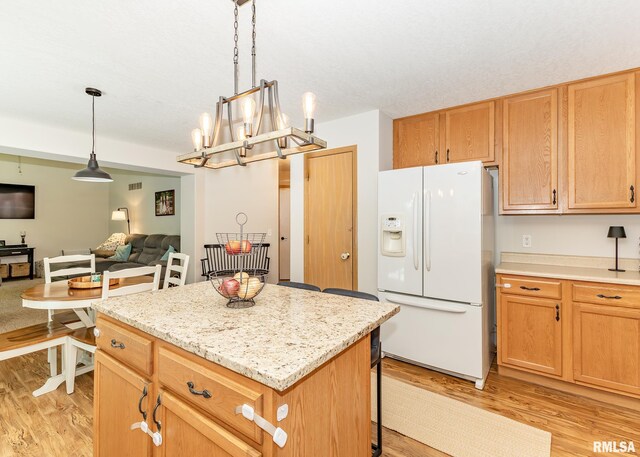 624 Mineral Creek Dr, Colona, IL 61241 - kitchen featuring white fridge with ice dispenser, light wood-type flooring, open floor plan, and a kitchen island
