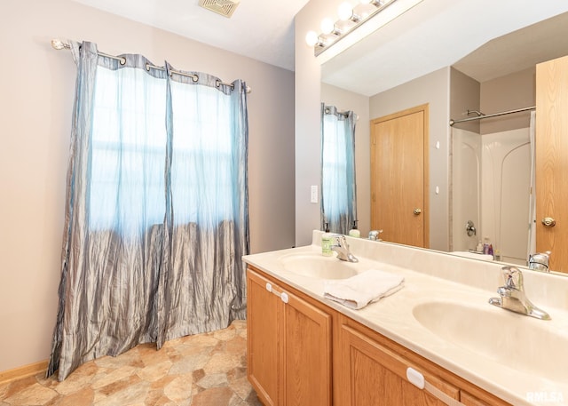 624 Mineral Creek Dr, Colona, IL 61241 - bathroom featuring double vanity, stone finish floors, and a shower