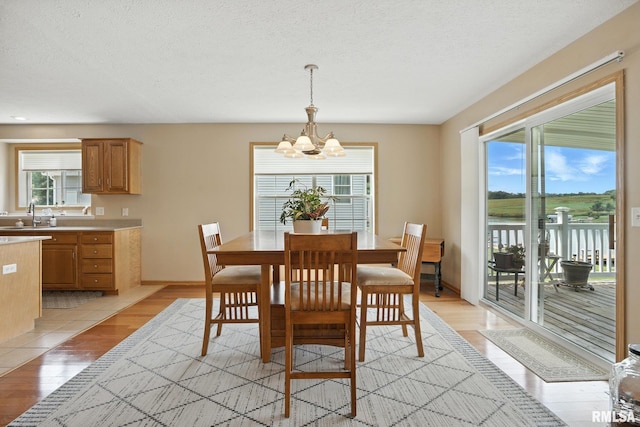 106 Valley View Dr, Sherrard, IL 61281 - dining room with a chandelier, light wood finished floors, and a textured ceiling
