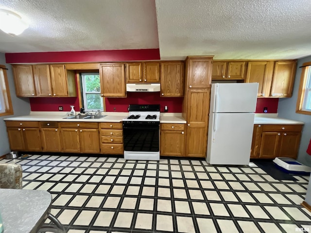 915 S 5th St, Clinton, IA 52732 - kitchen featuring freestanding refrigerator, gas range, range hood, a textured ceiling, and brown cabinets