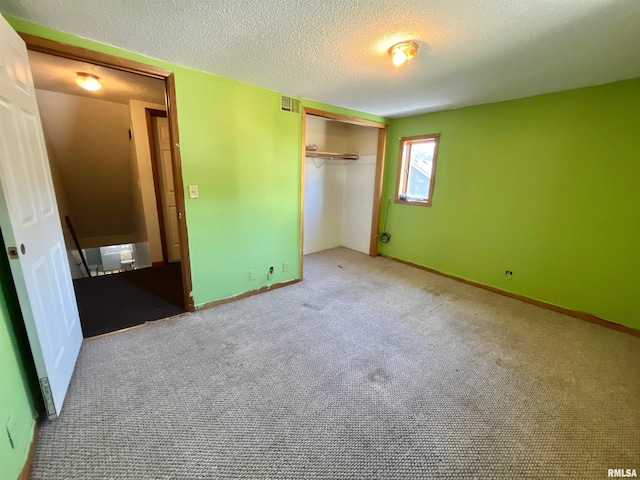 915 S 5th St, Clinton, IA 52732 - unfurnished bedroom featuring carpet flooring, a closet, and a textured ceiling