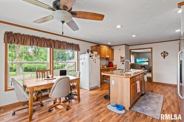 524 6th St, Andover, IL 61233 - kitchen featuring freestanding refrigerator, dishwasher, a center island with sink, brown cabinetry, and light wood finished floors