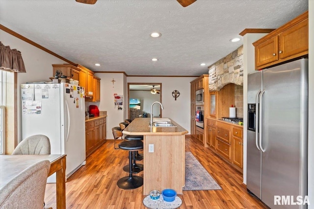 524 6th St, Andover, IL 61233 - kitchen featuring appliances with stainless steel finishes, ceiling fan, crown molding, brown cabinetry, and a textured ceiling