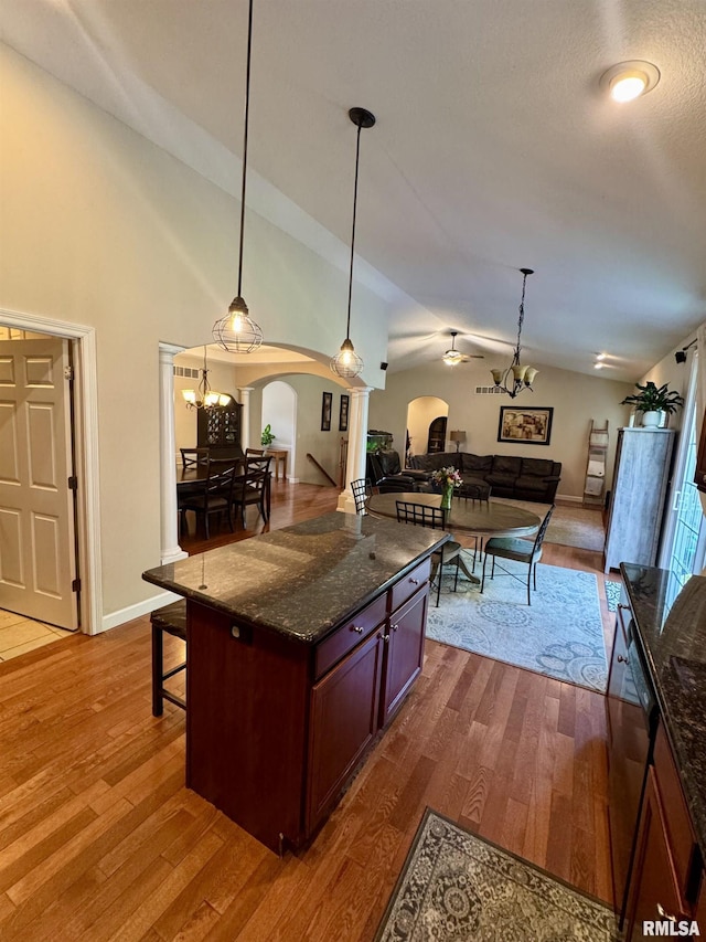 310 Westminster Rd, Germantown Hills, IL 61548 - kitchen with arched walkways, open floor plan, lofted ceiling, dark wood-style flooring, and hanging light fixtures