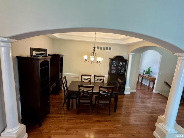 310 Westminster Rd, Germantown Hills, IL 61548 - dining space with decorative columns, a raised ceiling, dark wood-style floors, arched walkways, and a chandelier