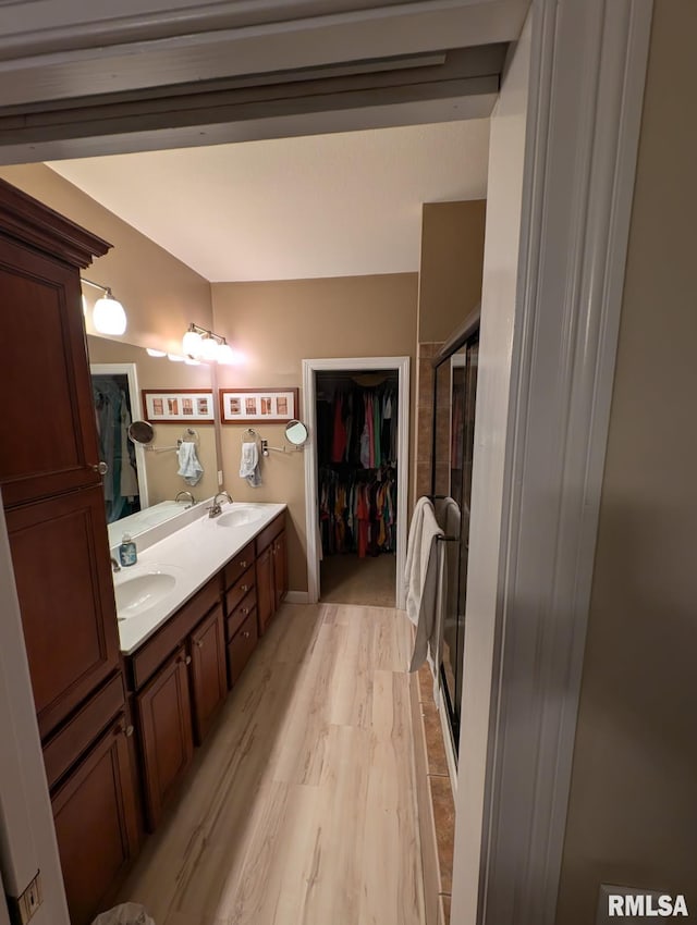 310 Westminster Rd, Germantown Hills, IL 61548 - bathroom featuring double vanity, a stall shower, a walk in closet, and wood finished floors