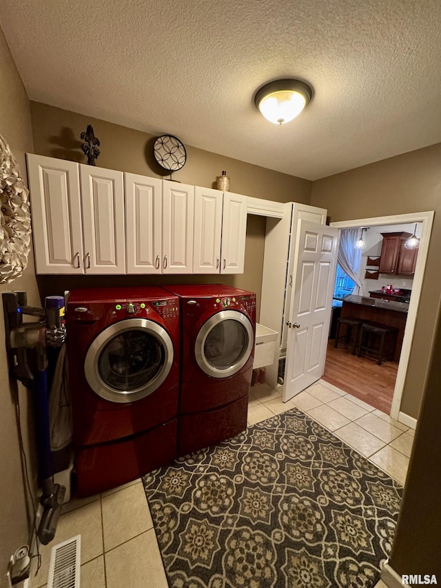 310 Westminster Rd, Germantown Hills, IL 61548 - laundry room featuring separate washer and dryer, light tile patterned floors, cabinet space, and a textured ceiling