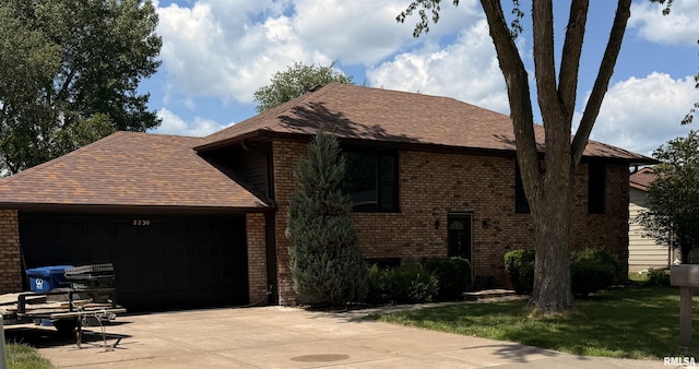 2230 Emerald Dr, Davenport, IA 52804 - view of front facade featuring brick siding, an attached garage, driveway, and roof with shingles