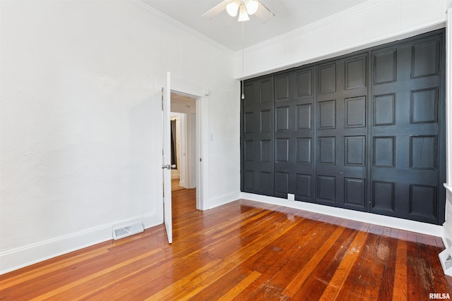 107 S High St, Port Byron, IL 61275 - unfurnished bedroom with hardwood / wood-style floors, ornamental molding, a closet, and a ceiling fan