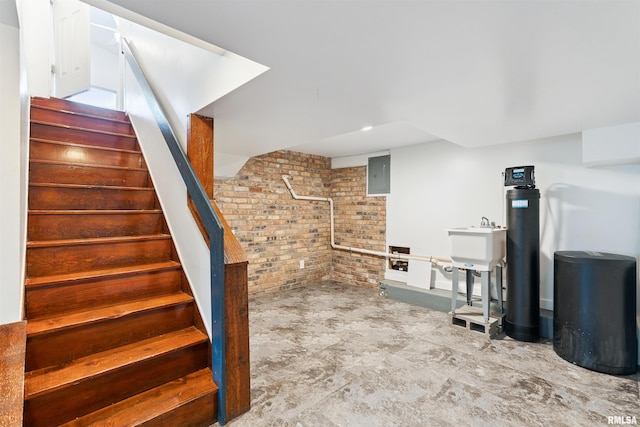 107 S High St, Port Byron, IL 61275 - finished below grade area featuring brick wall, electric panel, a water softener system, and stairs