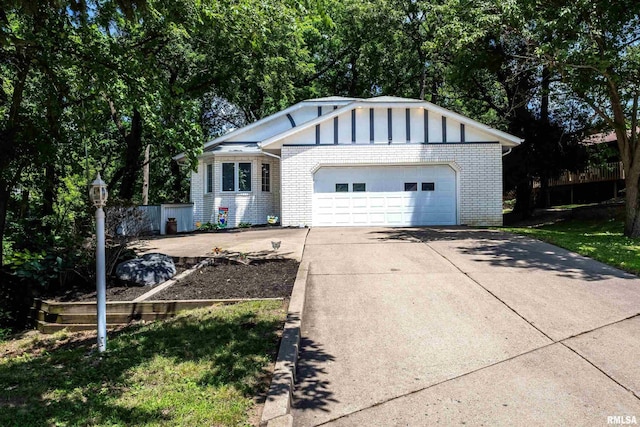 885 47th Ave, East Moline, IL 61244 - view of front of property with brick siding, a garage, concrete driveway, and board and batten siding